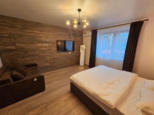 a bedroom with a bed and a wall with a television at Arbor Inn in Braşov