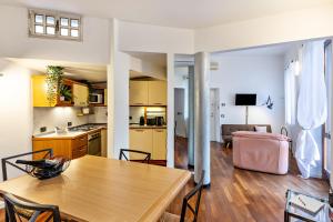 eine Küche und ein Wohnzimmer mit einem Holztisch und Stühlen in der Unterkunft la vigna del Vescovo in Verona