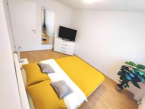 a bedroom with a yellow bed and a tv at Top apartment with 2 bedrooms and fully equiped in Haag
