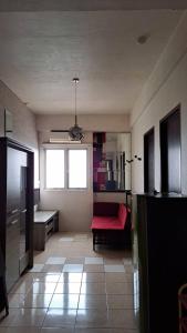 - un salon avec un canapé rouge et une fenêtre dans l'établissement Juar Room The Suites Apartment, à Bandung