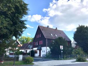 um grande celeiro preto e branco numa rua em Ferienhaus Chalet Dr. Winkler em Speichersdorf