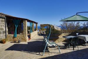 eine Terrasse mit einem Tisch und einem Sonnenschirm in der Unterkunft Case Vacanze La Cernia Bruna in Ustica