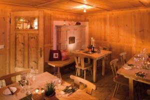 une salle à manger avec des murs en bois, des tables et des bougies dans l'établissement Naze`s Hus Mellau, à Mellau