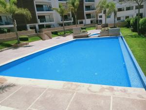 uma grande piscina azul em frente a um edifício em luxueux appartement touristique em Agadir