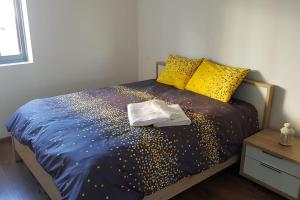 um quarto com uma cama com lençóis e almofadas com lantejoulas douradas em luxueux appartement touristique em Agadir
