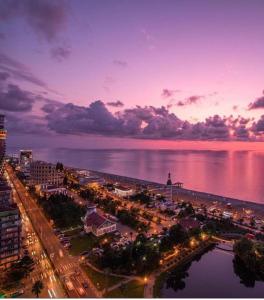 a view of a city at night with the water at Luxury Apartments in Batumi
