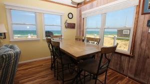 een eetkamer met een tafel en stoelen en de oceaan bij OCEANFRONT, Ocean Views, Beach Access, Close to Shopping, KH123, Pelican's Watch in Kitty Hawk +24 foto's