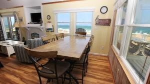 een eetkamer met een tafel en stoelen en de oceaan bij OCEANFRONT, Ocean Views, Beach Access, Close to Shopping, KH123, Pelican's Watch in Kitty Hawk
