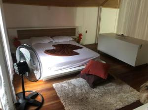 a bedroom with a large bed and a fan at Chalé Paraíso Corumbau in Prado