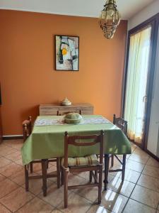 a dining room with a green table and chairs at L'angolo di Anna in Pieve di Soligo
