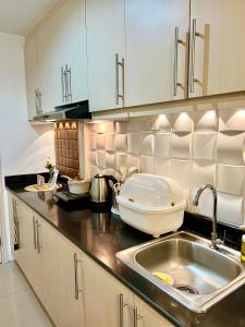 a kitchen with a sink and a counter top at Sea Residences: Eyal’s Suite Condotel near MOA/Mall of Asia in Manila