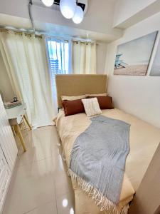 a bedroom with a bed with a blanket on it at Sea Residences: Eyal’s Suite Condotel near MOA/Mall of Asia in Manila