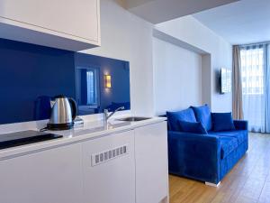 a kitchen with a blue sofa and a blue couch at Luxury Apartments in Batumi