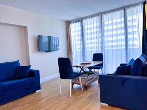 a living room with a blue couch and a table and chairs at Luxury Apartments in Batumi