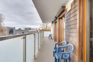 einen Balkon mit blauen Stühlen auf einem Gebäude in der Unterkunft Lasek Marceliński 2-Bedroom Apartment in Posen