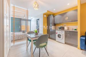 eine Küche mit einem Tisch und einer Waschmaschine in der Unterkunft Cosy lounge suit à 10 min de l'aéroport CDG TREMBLAY EN FRANCE in Tremblay En France