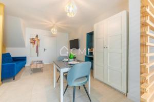 ein Wohnzimmer mit einem Tisch und einem blauen Stuhl in der Unterkunft Cosy lounge suit à 10 min de l'aéroport CDG TREMBLAY EN FRANCE in Tremblay En France