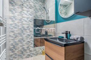 ein Badezimmer mit Waschbecken und Spiegel in der Unterkunft Cosy lounge suit à 10 min de l'aéroport CDG TREMBLAY EN FRANCE in Tremblay En France + 7 Fotos