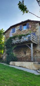 un edificio con un balcón en el lateral. en Gites les Tillets -Noyer, en Montet-et-Bouxal