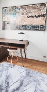 a desk with a chair and a painting on a wall at Luxueux appartement sur jardin in Paris