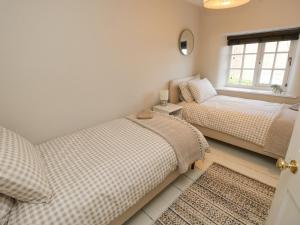 a bedroom with two beds and a window at Saltwater Cottage in Ventnor