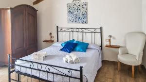een slaapkamer met een bed met blauwe kussens en een stoel bij Antico Pioppo in Sale