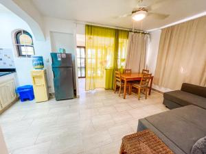 ein Wohnzimmer mit einem Kühlschrank und einem Tisch in der Unterkunft Garden & Ocean View VILLAS & Apartments WiFi BBQ Beach CLUB & SPA in Punta Cana