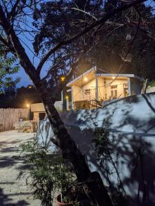 Rilassare stays cottage في Pedong: منزل أمامه شجرة
