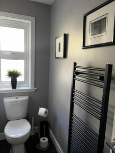 a bathroom with a toilet and a window at Holly Lodge - Luxury Two Kingsize bedrooms with private entrance in Oban