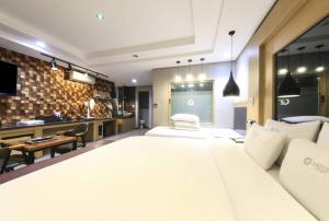 釜山にあるQ5 Hotel Busan Songdoの大きなベッドルーム(大型ベッド1台付)、キッチンが備わります。