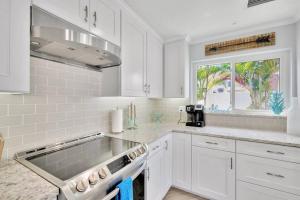 a kitchen with white cabinets and a sink and a window at Island Paradise 3 Bed Waterfront/Heated Pool in Clearwater Beach