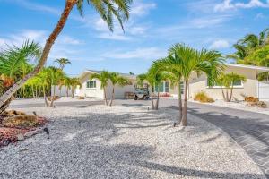 a home with palm trees in the driveway at Island Paradise 3 Bed Waterfront/Heated Pool in Clearwater Beach