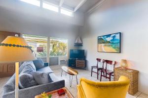 a living room with a blue couch and chairs at Princeville Puamana 21A in Princeville