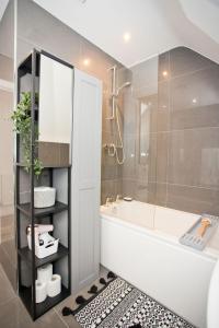 a bathroom with a tub and a glass shower at Stylish 2 Bedroom Apt - Parking - 5 Mins walk to Beach in Bournemouth