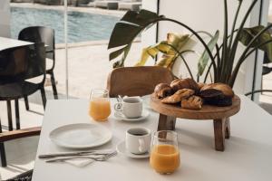 un tavolo con un piatto di pane e tazze di succo d'arancia di Sundunes Hotel Naxos a Plaka
