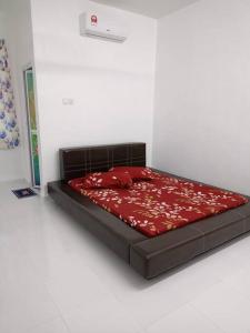 a bed in a room with a red comforter at Homestay Usrati 17J (untuk muslims sahaja) in Kangar