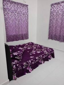a purple bed in a room with two windows at Homestay Usrati 17J (untuk muslims sahaja) in Kangar