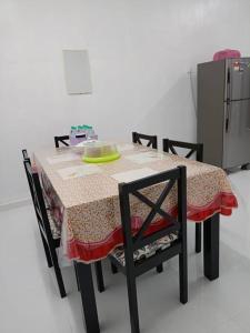 a table with two chairs and a table with a table cloth at Homestay Usrati 17J (untuk muslims sahaja) in Kangar