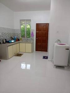 a kitchen with white walls and a brown door at Homestay Usrati 17J (untuk muslims sahaja) in Kangar
