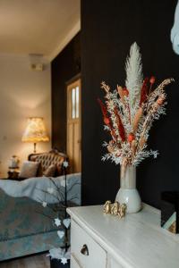 eine Vase mit Blumen auf einem Tisch im Wohnzimmer in der Unterkunft Huis 7 in Ypern