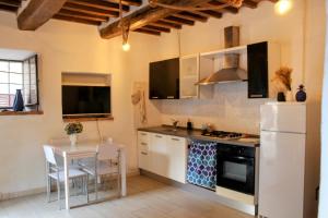 a kitchen with a white refrigerator and a table at La Casina in Montecatini Val di Cecina