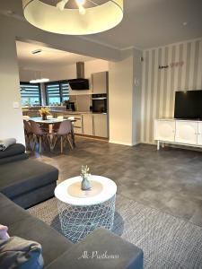 a living room with a couch and a table at Coast House 25 -TRZĘSACZ SUNNY SIDE BALTIC in Trzęsacz