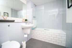 a bathroom with a toilet and a sink and a tub at Stylish 2 Bed Flat in HEART of Cardiff City Centre in Cardiff