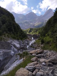 um rio com rochas e montanhas ao fundo em Pirineos como en casa 2 em Bielsa