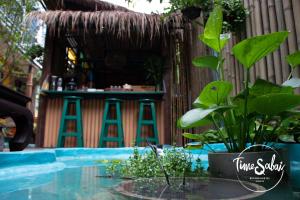 a patio with a table and a bar with plants at Time Sabai 134 in Bangkok