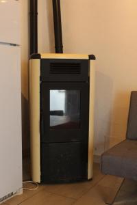 a stove sitting in a room next to a chair at La Casina in Montecatini Val di Cecina