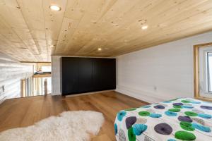 a bedroom with a bed and a large black screen at Mini Muskoka Getaway - Huntsville in Huntsville