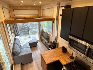 a tiny house with a living room and a desk at Mini Muskoka Getaway - Huntsville in Huntsville
