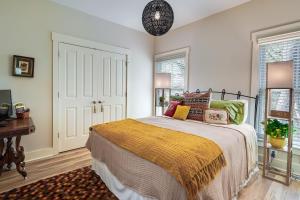 a bedroom with a bed with colorful pillows on it at Charming Granville Home with Porch - Walk Downtown! in Granville
