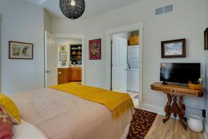 een slaapkamer met een bed, een bureau en een televisie bij Charming Granville Home with Porch - Walk Downtown! in Granville